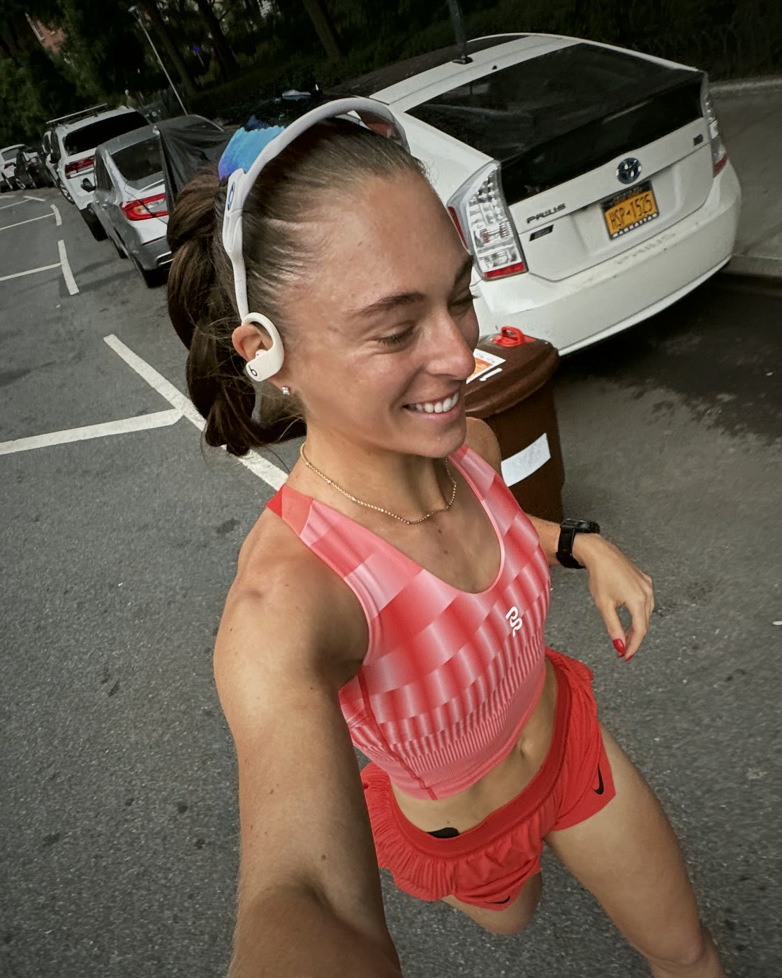 Brianna smiling mid-run in a red patterned crop and red shorts