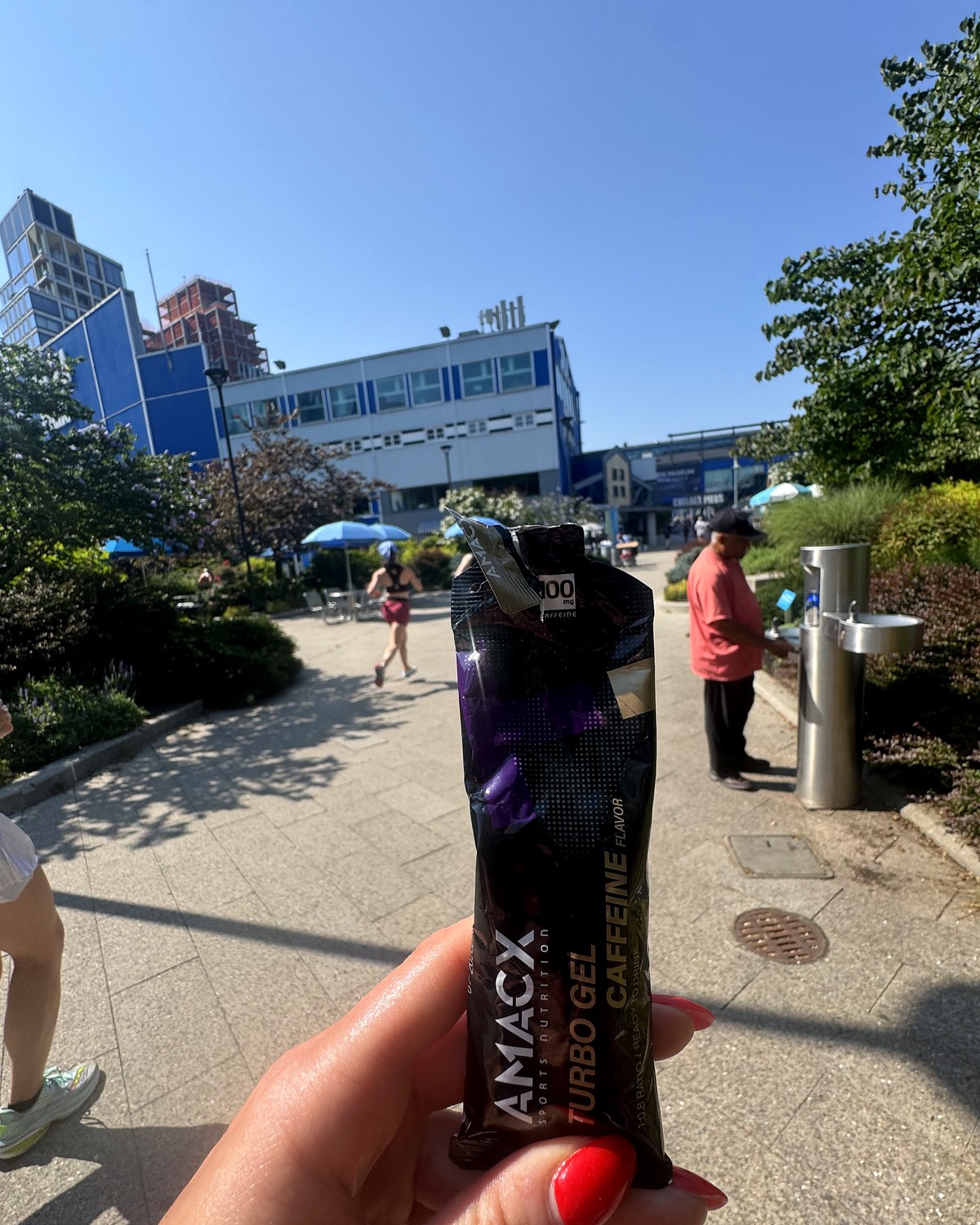 Holding up an Amacx Turbo Gel Caffeine on the waterfront path