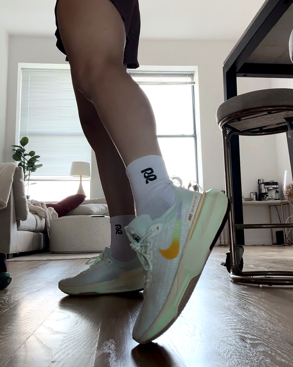 Mint Nike Invincible with a gradient swoosh and white crew socks, from the floor